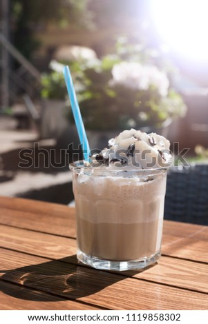 The vertical shot, glass of Iced coffee, on a wooden table. selective focus with the ice