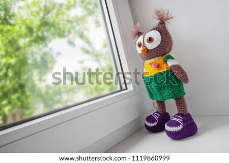 Handmade crochet toy owl near the window
