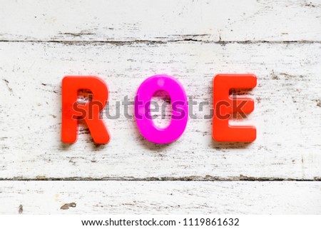 Color alphabet in word ROE (Abbbreviation of Return on equity) on grunge old white wood background