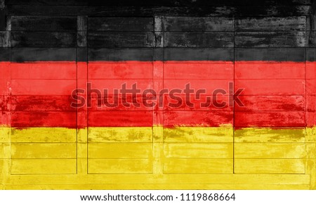 German flag painted on a wooden billboard  against a stone wall