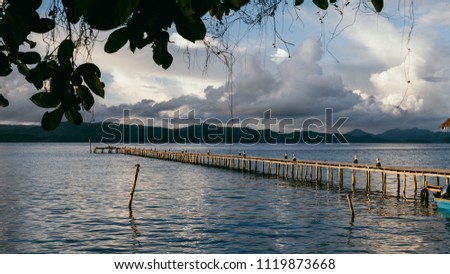 Cloudscape with wooden pier in kri island before tropical thunderstorm. Raja Ampat archipelago, West papua, Indonesia