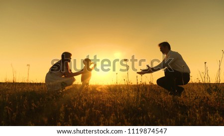 young Asian family in field with baby 1 year on hand, concept of family happiness, beautiful sunlight, sunset