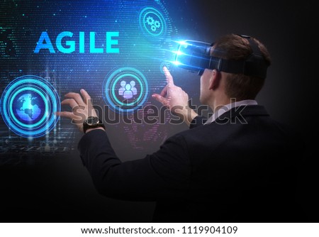 Business, Technology, Internet and network concept. Young businessman working on a virtual screen of the future and sees the inscription: Agile