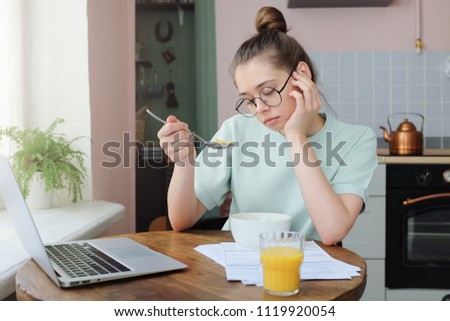 No appetite. Frustrated bored young woman looking at bowl with some tasteless cereal. Heathy but flavorless food, dislike concept. 
 Royalty-Free Stock Photo #1119920054