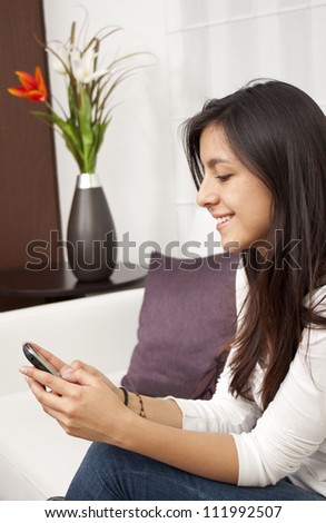 Beautiful woman texting using a mobile phone in the home