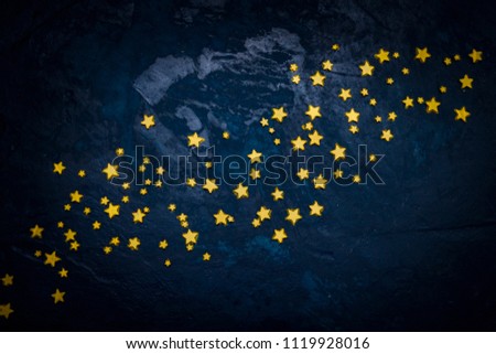 Decorative stars on a dark blue background. Concept of the night sky. Can be used as wallpaper or background. Flat lay, top view. Royalty-Free Stock Photo #1119928016