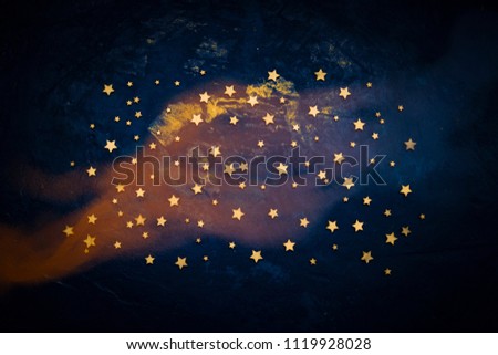 Decorative stars on a dark blue background. Concept of the night sky. Can be used as wallpaper or background. Flat lay, top view.