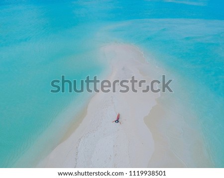 luxury Tropical island of white sandy beach with blue lagoon in the sea sky in the Maldives. And a beautiful woman who is sunbathing .