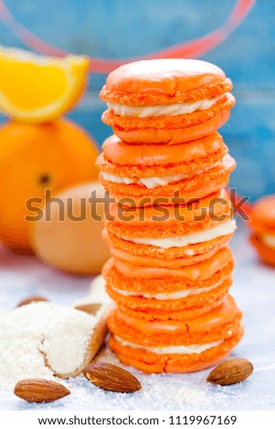 Homemade orange and mascarpone french macarons macaroons on table with ingredients
