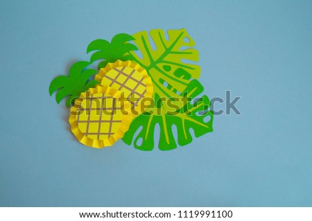 Fruits made from paper on a blue background.Pineapple. View from above. Children's creativity. Tropical party of Hawaii.