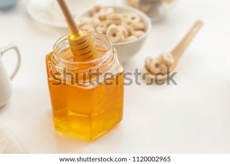 Pouring aromatic honey into jar, closeup