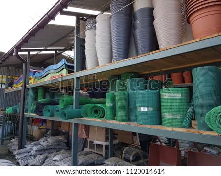 Stelage with plastic products in stock. Products for gardening and vegetable gardens. Objects that facilitate the cultivation and care of plants. Vases and boxes for flowers.