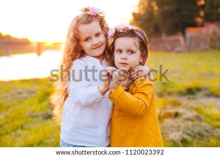 Two pretty young girls making heart from hands