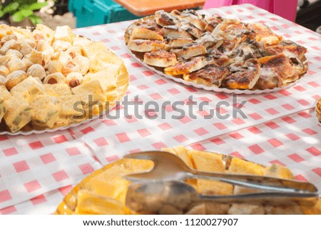 Dishes of fried and breaded food for a wedding in the countryside outdoors in the summer.