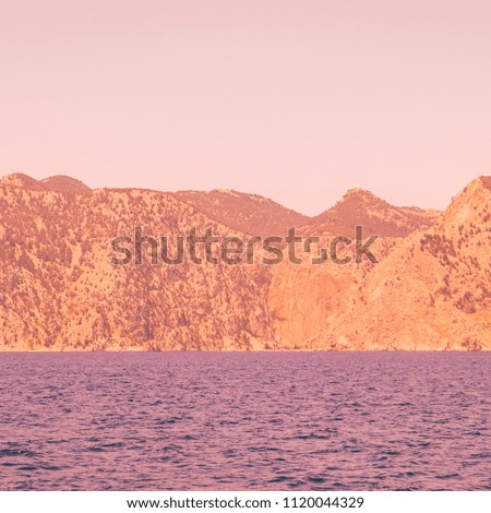 alien mountain landscape and sea. bright neon orange and purple colors. minimal and surreal. summer vacation.