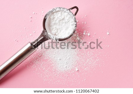 Strainer with powder sugar on pink background, top view Royalty-Free Stock Photo #1120067402