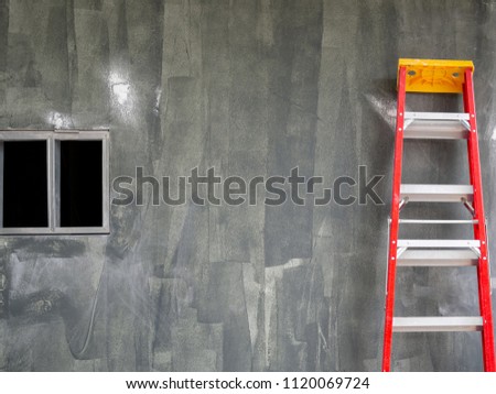 Construction Building Area with Standing Red Ladder and Window on Concrete Wall Background with Copy Space.