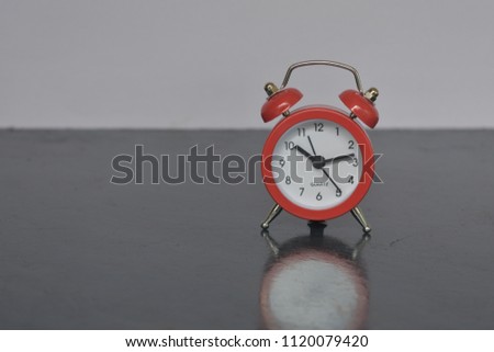 Red alarm clock on the white and dark backdrops and background