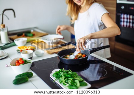 Young blonde woman cooking in the kitchen. Healthy Food. Dieting Concept. Healthy Lifestyle. Cooking At Home. Prepare Food Royalty-Free Stock Photo #1120096310