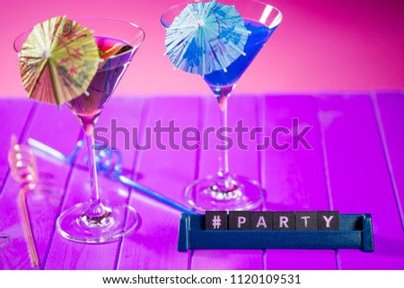 Hashtag party title word text with fun vacation beach cocktail glasses. Letters on a stand spelling #party as an ideal invitation or celebration greeting card image.