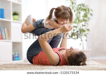 love and family concept - happy mom and child daughter having fun pastime at home