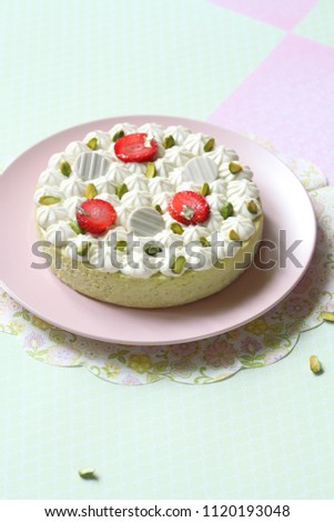 Pistachio Cheesecake with Vanilla Diplomat Cream, on light green and pink background. 