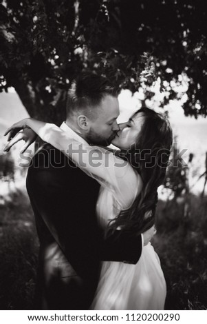 Beautiful wedding couple outdoor kissing and hugging