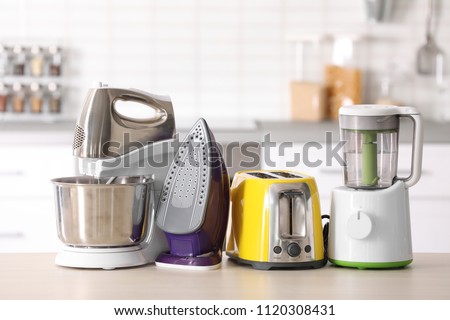 Household and kitchen appliances on table against blurred background Royalty-Free Stock Photo #1120308431