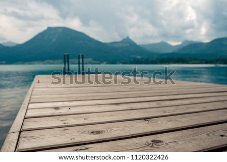 ootbridge with a pool ladder in the lake in Austria which wolfgangsee is called with mountains in the background
