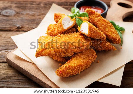 Delicious crispy fried breaded chicken breast strips . Royalty-Free Stock Photo #1120331945