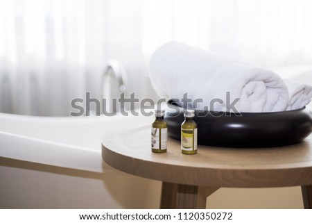 White towel and massage bath oil on table in bathroom. Abstract SPA photo.