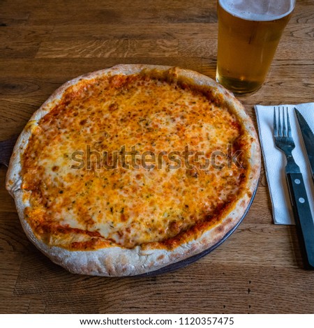 Pizza Margarita and glass of beer in Icelandic pizzeria, Iceland, summer time, indoor