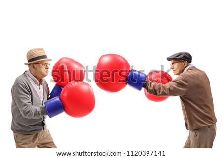 Seniors fighting each other with big boxing gloves isolated on white background Royalty-Free Stock Photo #1120397141