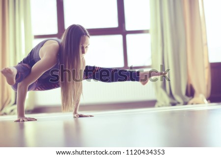 gymnasium, yoga classes / a girl engaged in yoga, a trom in a large gym, light and rays of the sun. concept of yoga for women