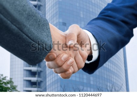 Handshake of businessmen against the background of a business center.