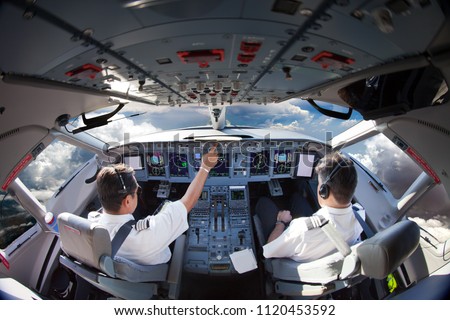 Flight Deck of modern aircraft. Pilots at work. Clouds view from the plane cockpit. Royalty-Free Stock Photo #1120453592