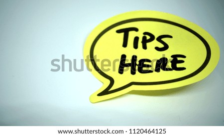 Written "tips here" on a cartoon shaped yellow sheet on a white background
