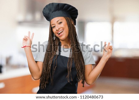 Portrait of a young black baker woman fun and happy, positive and natural, makes a gesture of victory, peace concept
