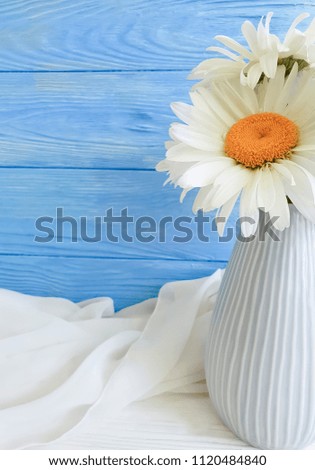 vase daisy on a wooden background