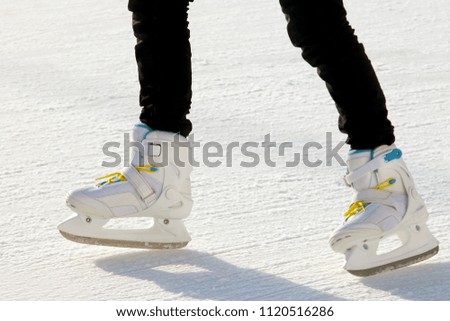 the legs of a man skating on the ice rink