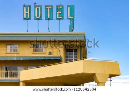 Dirty old hotel sign on the top of a highway motel in an American city