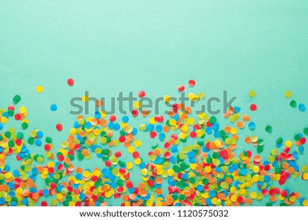 Colorful Confetti in front of blue Background.