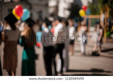 Students / applicants with colorful balloons at the celebration, holiday. Blurred picture, image. Graduates, students, bachelors, masters.