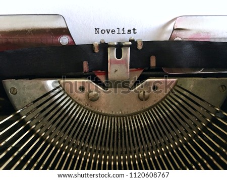 Novelist, writer occupation title heading typewritten in black ink on white paper on vintage manual typewriter machine