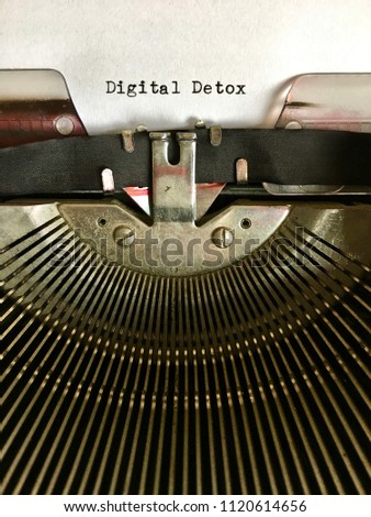 DIGITAL DETOX, heading title terminology typewritten in black ink on white paper on vintage manual typewriter machine