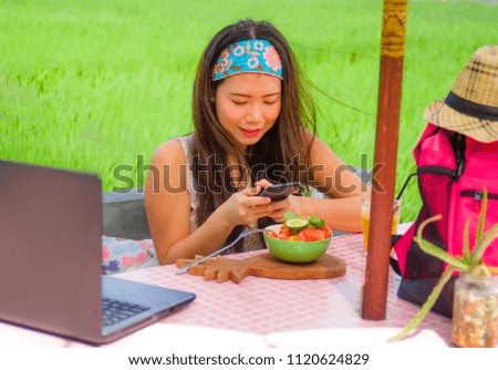 young happy and pretty digital nomad Asian Chinese girl taking picture of fruit salad with mobile phone for sharing on internet social media in healthy nutrition and travel blogger food review