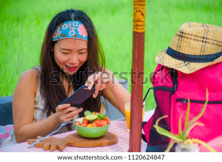 young happy and pretty digital nomad Asian Korean woman taking picture of fruit salad with mobile phone networking on internet social media in healthy nutrition and travel blogger food review