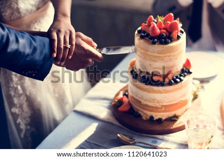 Couple Hands Cutting Wedding Cake Royalty-Free Stock Photo #1120641023