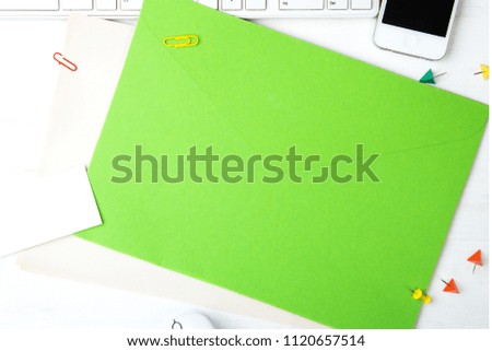 Green note paper on white Desk with keyboard and office supplies.Mockup