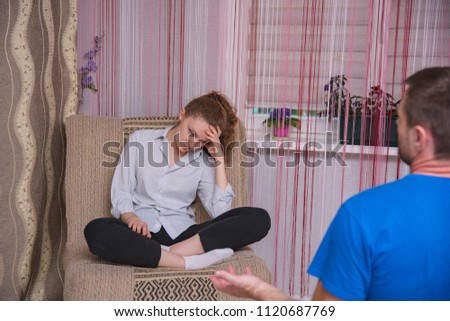 family problems, difficulties, quarrels between husband and wife in the room on the sofa. They are right in front of the camera and look unhappy